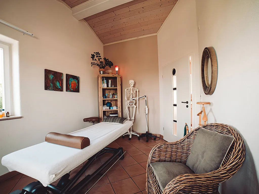Heller Behandlungsraum der Praxis mit Therapieliege
