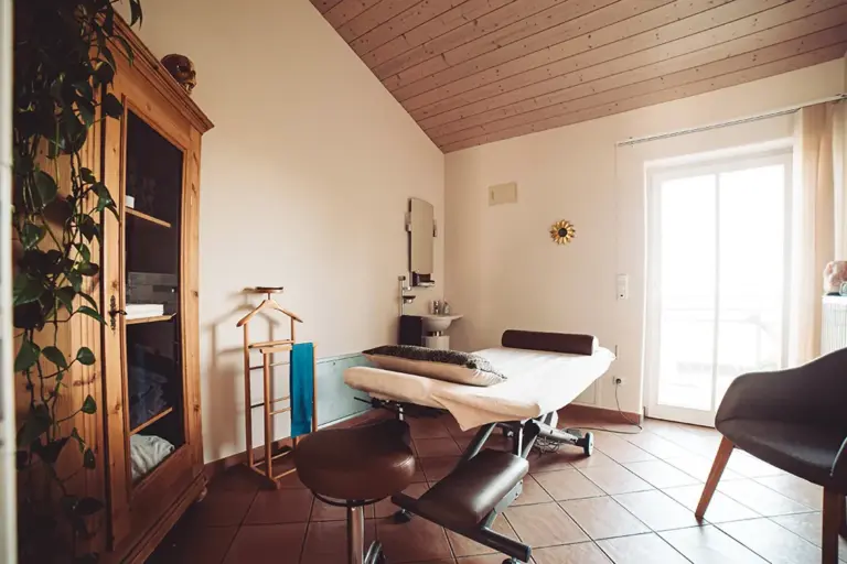 Behandlungsraum mit Liege unter einer Dachschräge
