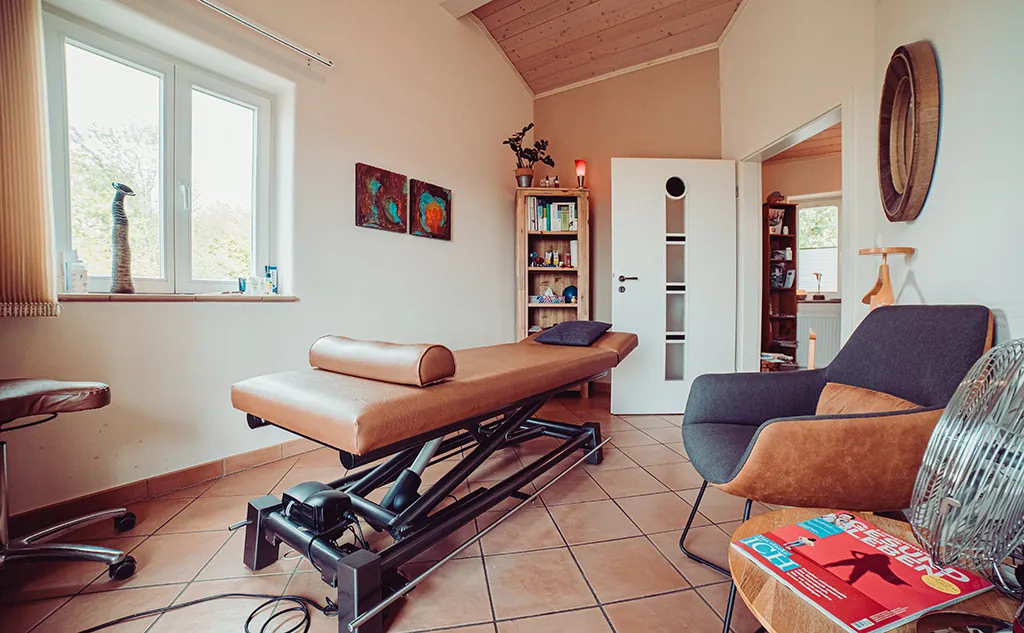 Therapieraum mit Behandlungsliege und Sessel