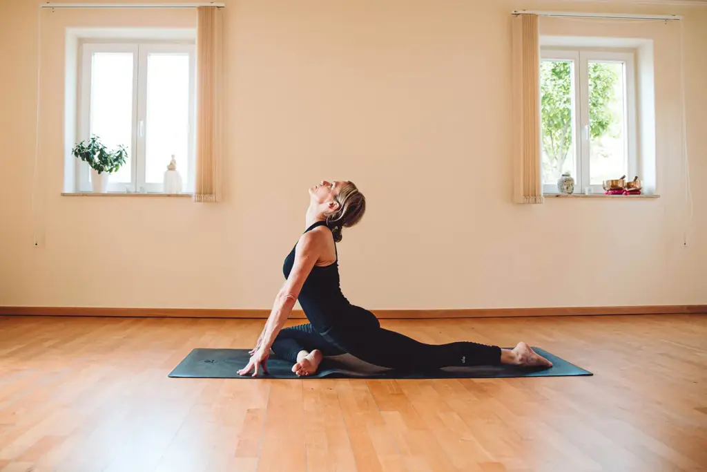 Yoga-Haltung auf der Matte im hellen Kursraum